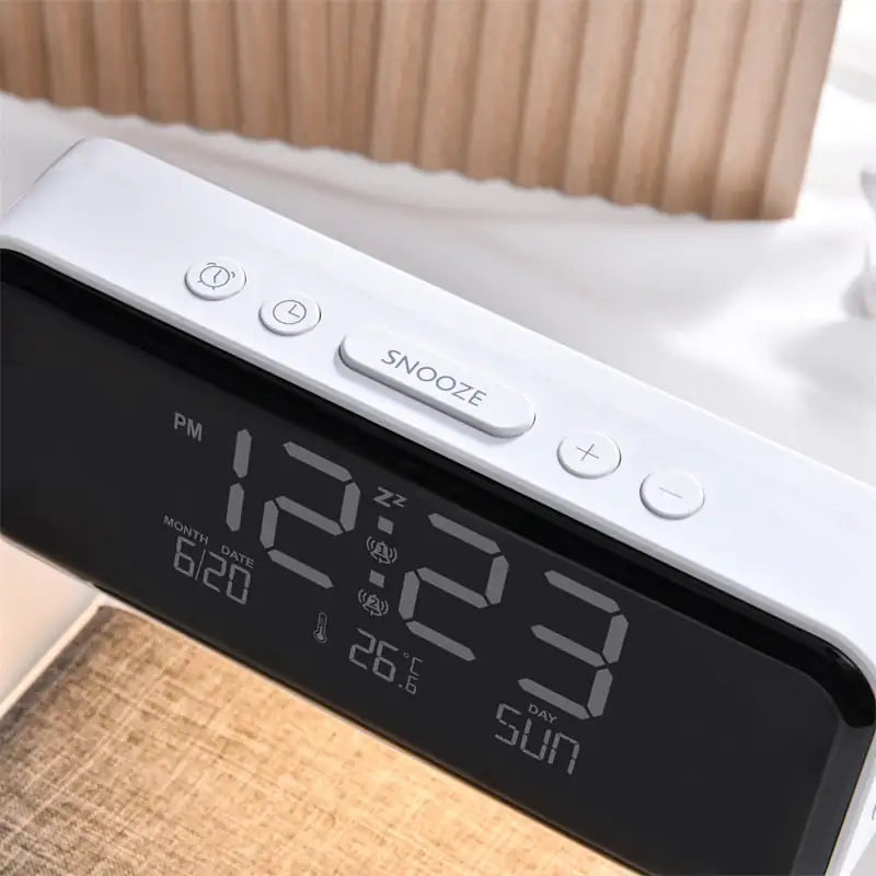 Despertador con pantalla LCD 3 en 1 junto a la cama