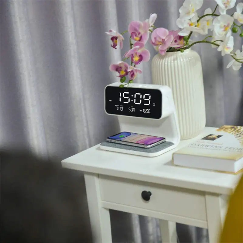 Despertador con pantalla LCD 3 en 1 junto a la cama